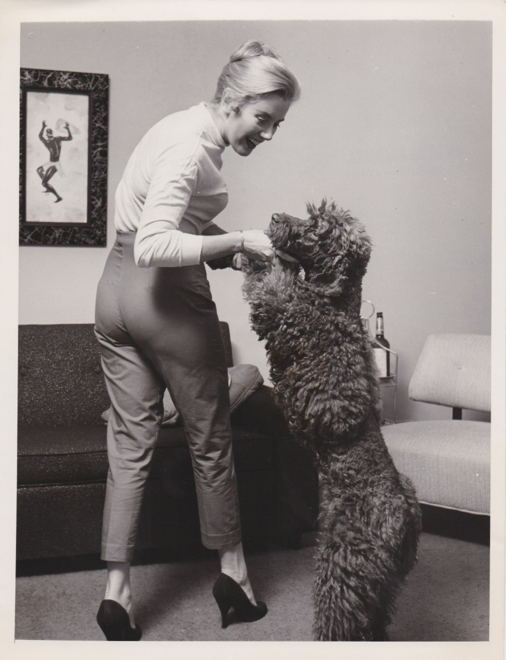 1957 Press Photo Actress Kathleen Nolan plays with her Pet Poodle Dog
