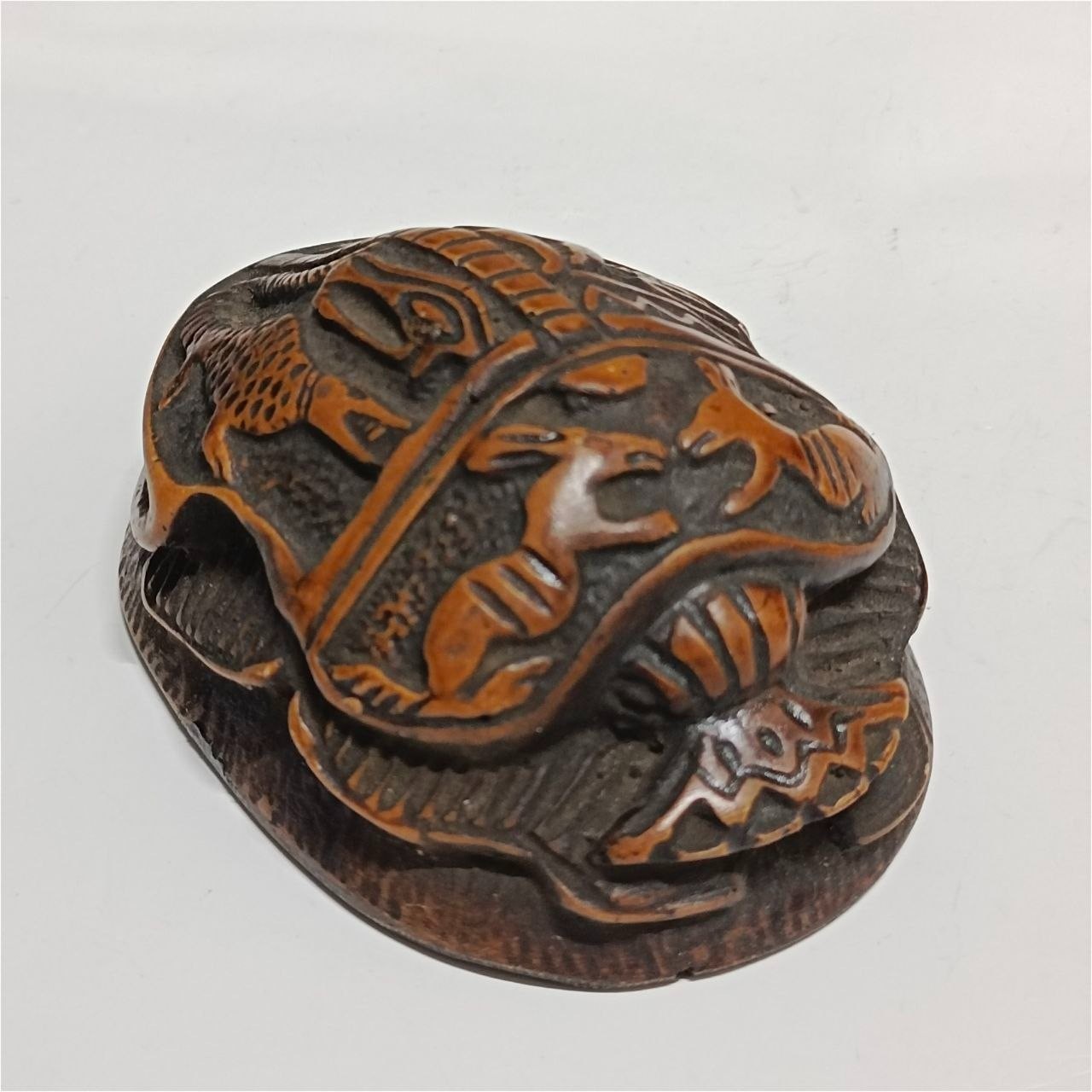 Ancient Egyptian scarab carving with intricate patterns brown and orange tones Ancient Egyptian scarab carving with intricate patterns brown and orange tones