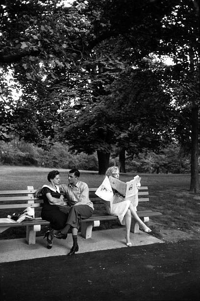 Marilyn Monroe reads a newspaper while sitting next to a man propo- Old Photo