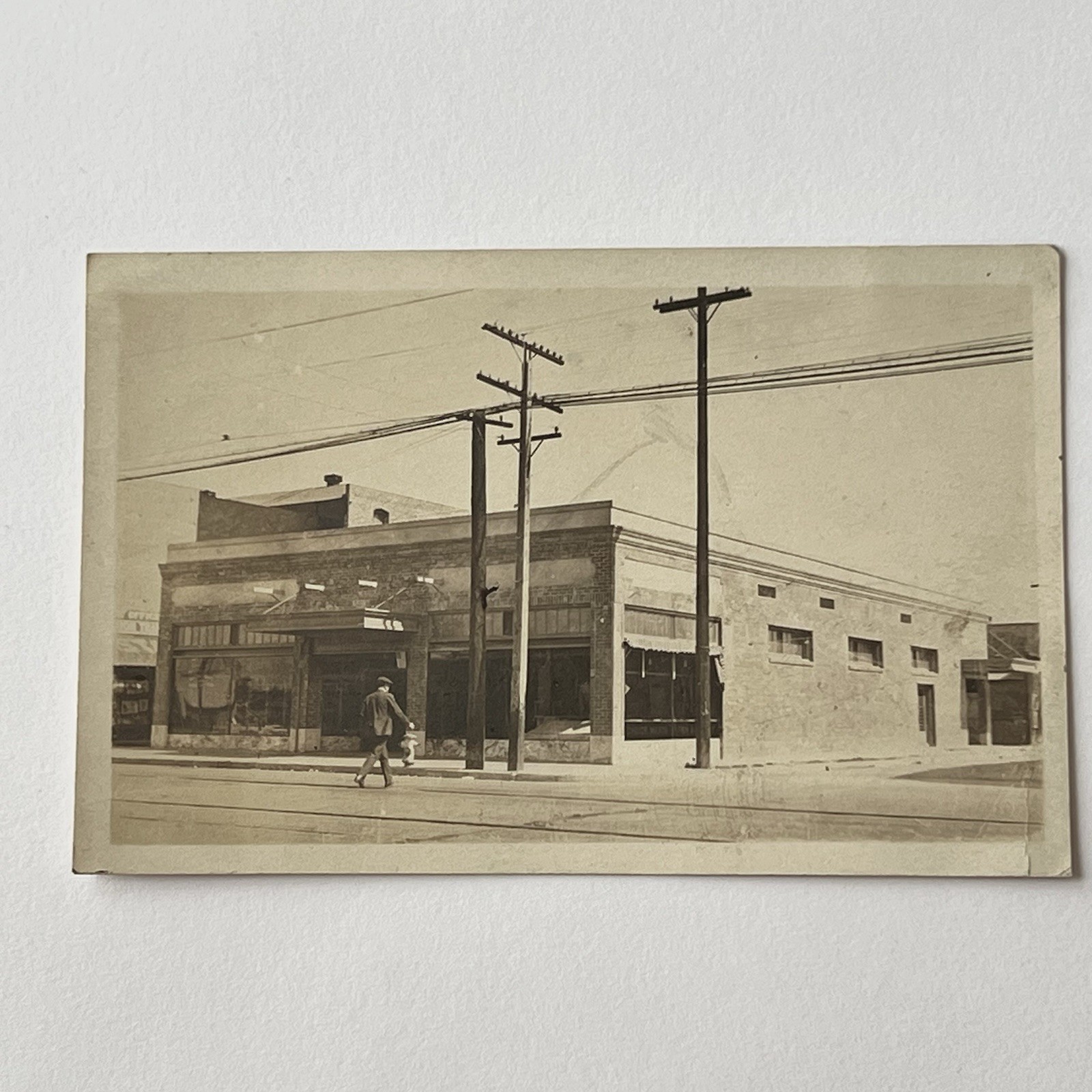 Antique RPPC Real Photograph Postcard Building Man Walking Across Street Poles