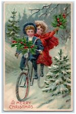 1907 Merry Christmas Children Riding Bicycle Holly Berries Embossed Postcard picture