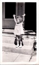 Joyful Toddler Girl with Raised Arms on Porch Steps, 1950s Snapshot Photo picture